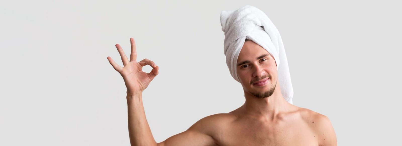 front view shirtless man with towel his head making okay sign